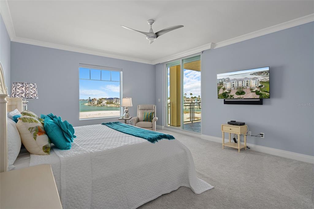A bright kitchen with white cabinetry and a center island overlooks a dining area and balcony — 650 COLLANY ROAD UNIT 405, TIERRA VERDE, FL