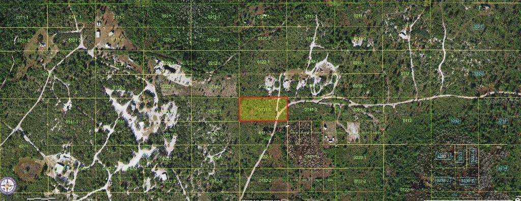 This is an aerial map showing a rectangular property highlighted in red within a wooded area — HOLOPAW GROVES ROAD, ST CLOUD, FL