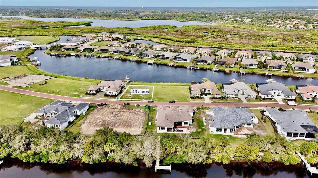 An aerial view shows a vacant residential lot highlighted in a waterfront neighborhood — 1707 RIO VISTA TERRACE, PARRISH, FL