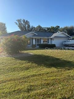A single-story house with a light-colored exterior, a garage, and a boat parked outside — 65 ALLWORTHY STREET, PORT CHARLOTTE, FL