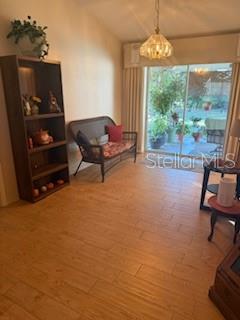 A living room features light wood-look tile flooring, a tall bookshelf, and a small bench — 65 ALLWORTHY STREET, PORT CHARLOTTE, FL