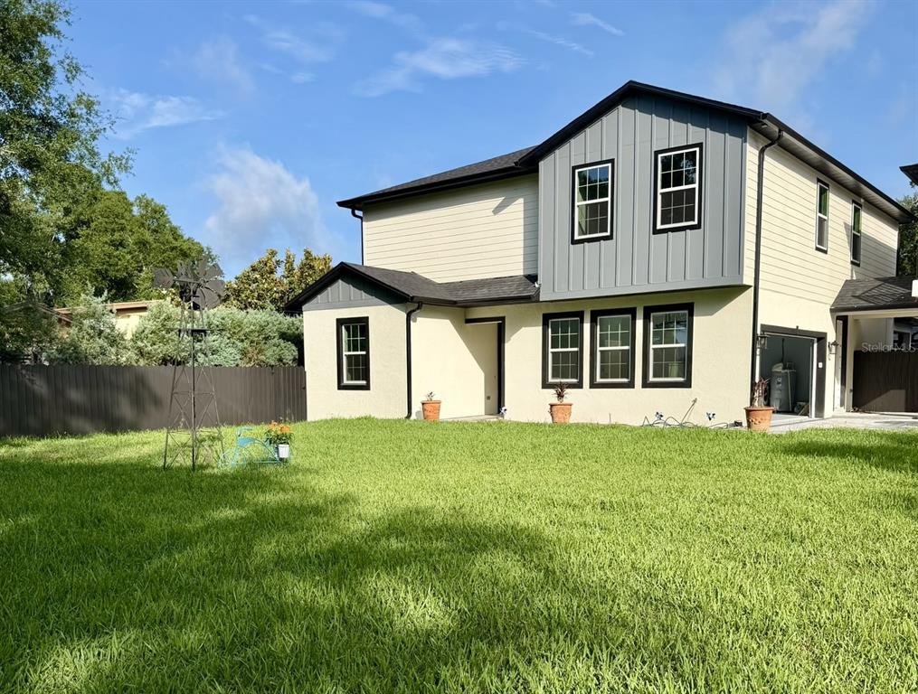 The exterior of a two-story house features beige siding, gray vertical paneling, and a lawn — 1450 IRMA ROAD, EUSTIS, FL