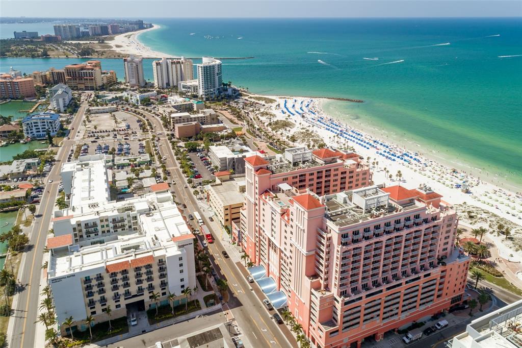 An aerial view of a coastal city featuring a large pink hotel and beach — 301 S GULFVIEW BOULEVARD UNIT 304, CLEARWATER BEACH, FL