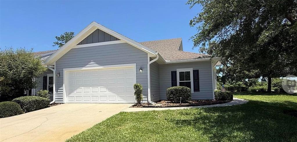 A light blue house with a two-car garage and a landscaped front yard — 12604 NW 11TH PLACE, NEWBERRY, FL