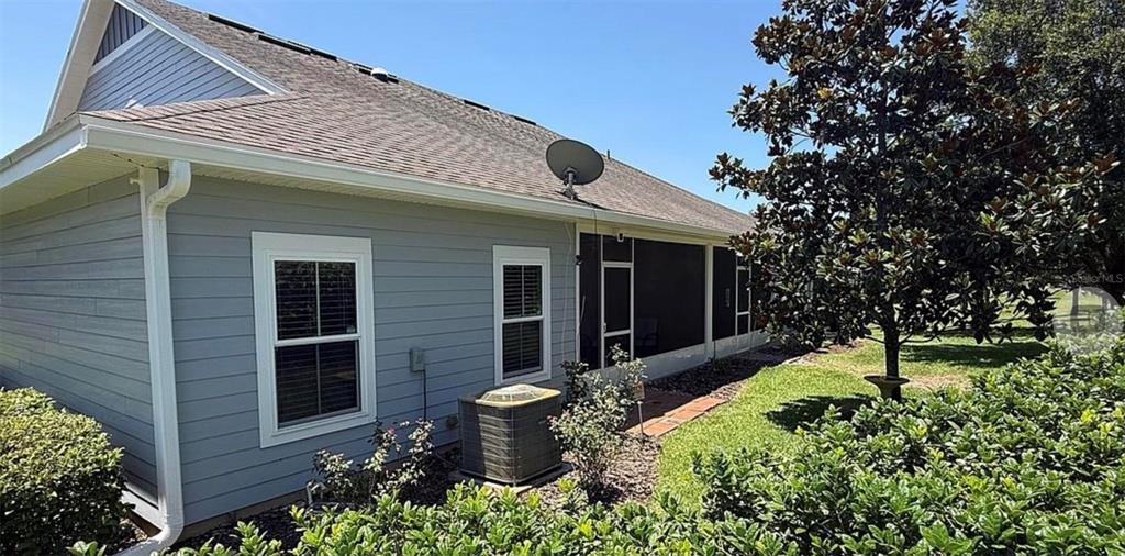 The exterior of a light blue house features a screened-in porch and an air conditioning unit — 12604 NW 11TH PLACE, NEWBERRY, FL