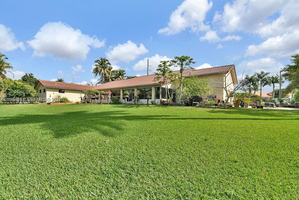A large, single-story house with a tiled roof sits behind a expansive green lawn — 5425 SW 190th Ave # 1, Southwest Ranches FL 33332, SOUTHWEST RANCHES, FL