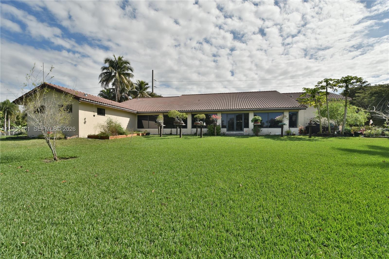 A single-story house with a tiled roof sits behind a large, grassy backyard — 5425 SW 190th Ave # 1, Southwest Ranches FL 33332, SOUTHWEST RANCHES, FL