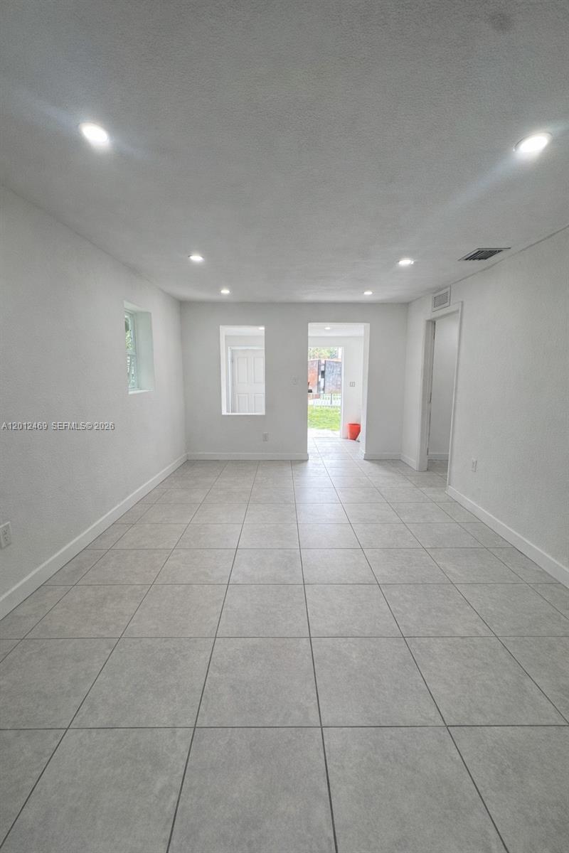 A kitchen features gray shaker cabinets, black countertops, and stainless steel appliances — 1861 NW 112th St, Miami FL 33167, MIAMI, FL