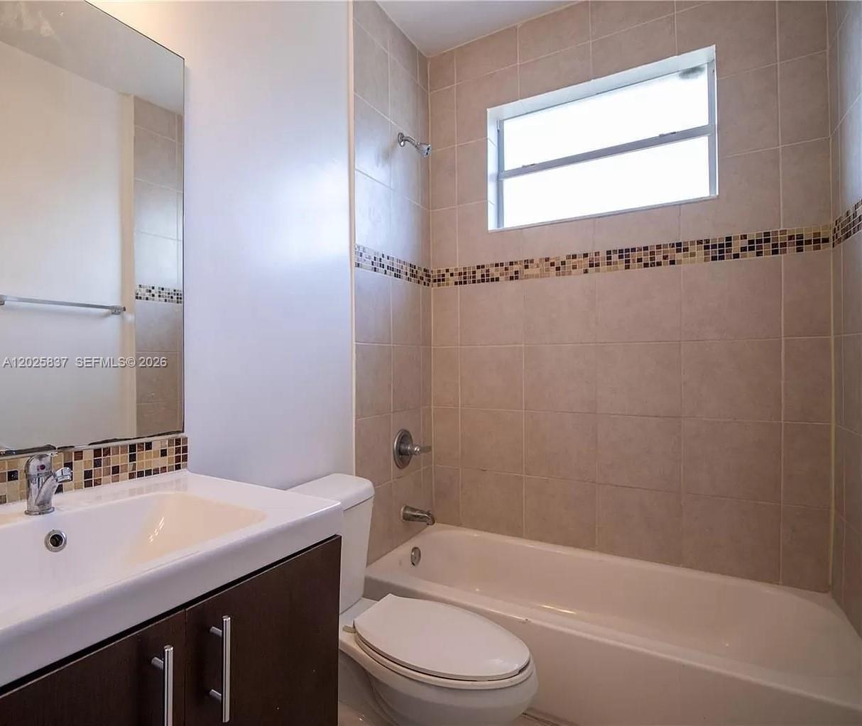A bathroom features a vanity with a mirror, a toilet, and a tiled shower-tub combination — 5416 NE 1st Ct # 2, Miami FL 33137, MIAMI, FL