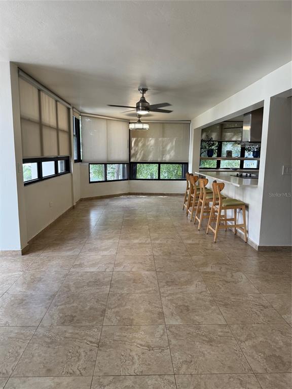 An open-concept room features tile flooring, a ceiling fan, and a breakfast bar with stools — 18 TAFT UNIT 2-S, SAN JUAN, PR