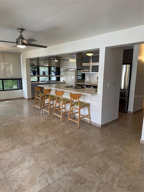 A kitchen with a breakfast bar, stainless steel appliances, and light-colored tile flooring — 18 TAFT UNIT 2-S, SAN JUAN, PR