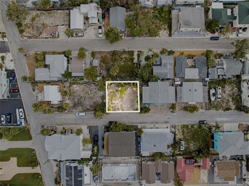 An aerial view shows a vacant, rectangular residential lot outlined in white between existing houses — 131 86TH TERRACE, ST PETERSBURG, FL