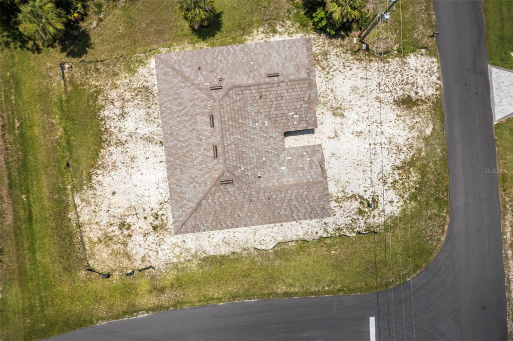 An aerial view shows a house with a brown shingled roof on a sandy lot — 16265 SAN EDMUNDO ROAD, PUNTA GORDA, FL
