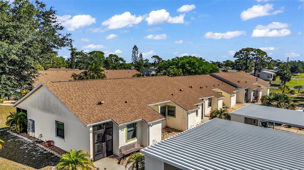 An aerial view shows a single-story residential building with a brown shingled roof — 6796 GASPARILLA PINES BOULEVARD UNIT 105, ENGLEWOOD, FL