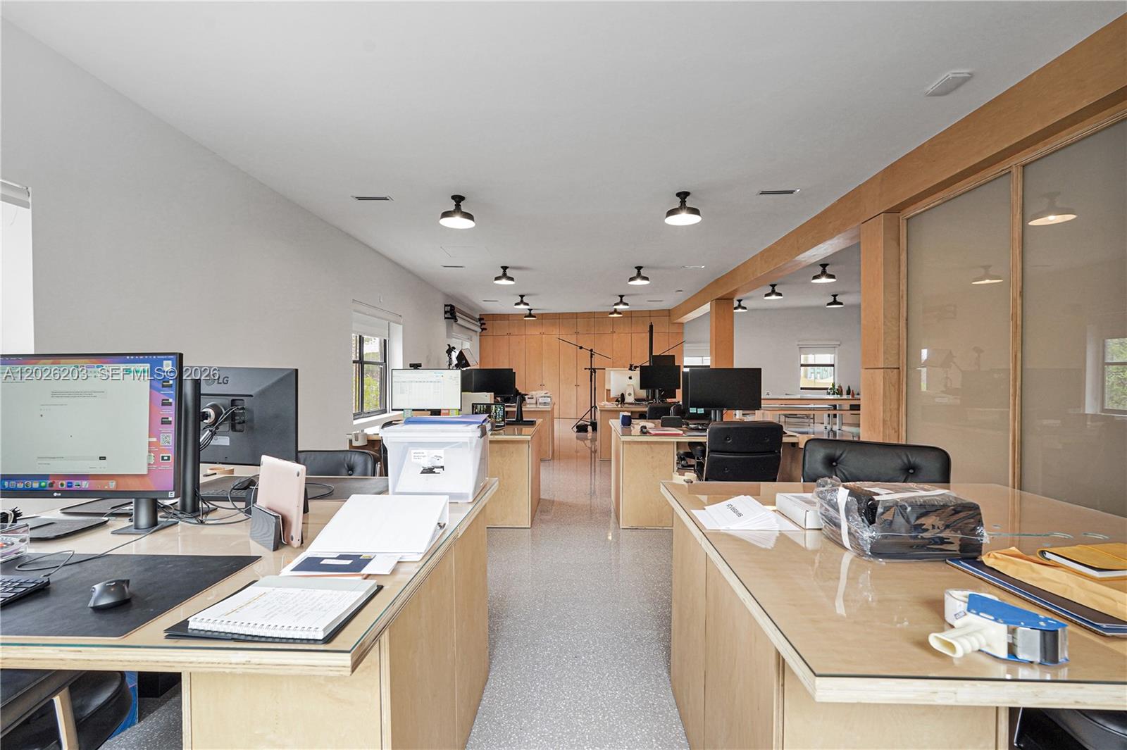 This office space features multiple desks, computer monitors, and light-colored wood cabinetry — 1800 N Miami Ave, Miami FL 33136, MIAMI, FL