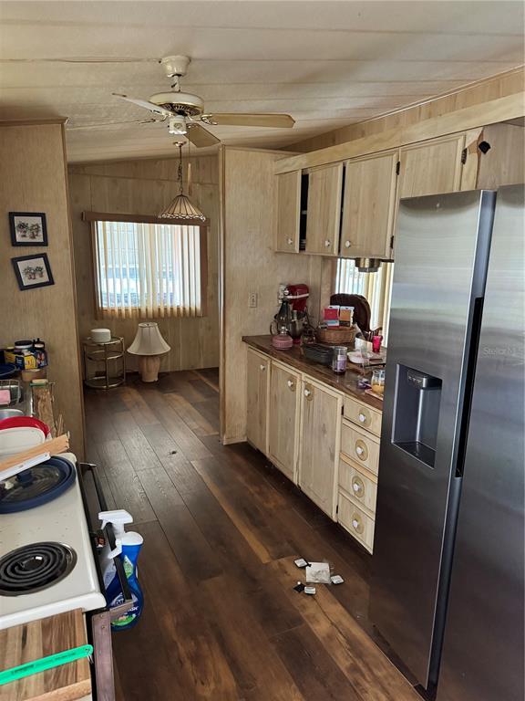 A kitchen with wood-paneled walls, light wood cabinets, and a stainless steel refrigerator — 14251 RIALTO AVENUE, BROOKSVILLE, FL