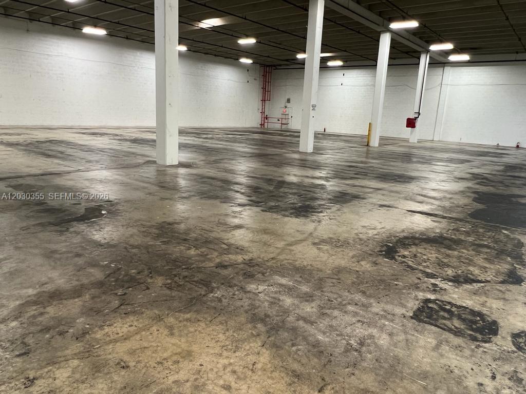 An empty industrial warehouse space features white support columns and a stained concrete floor — 2281 NW 95th Ave, Doral FL 33172, DORAL, FL