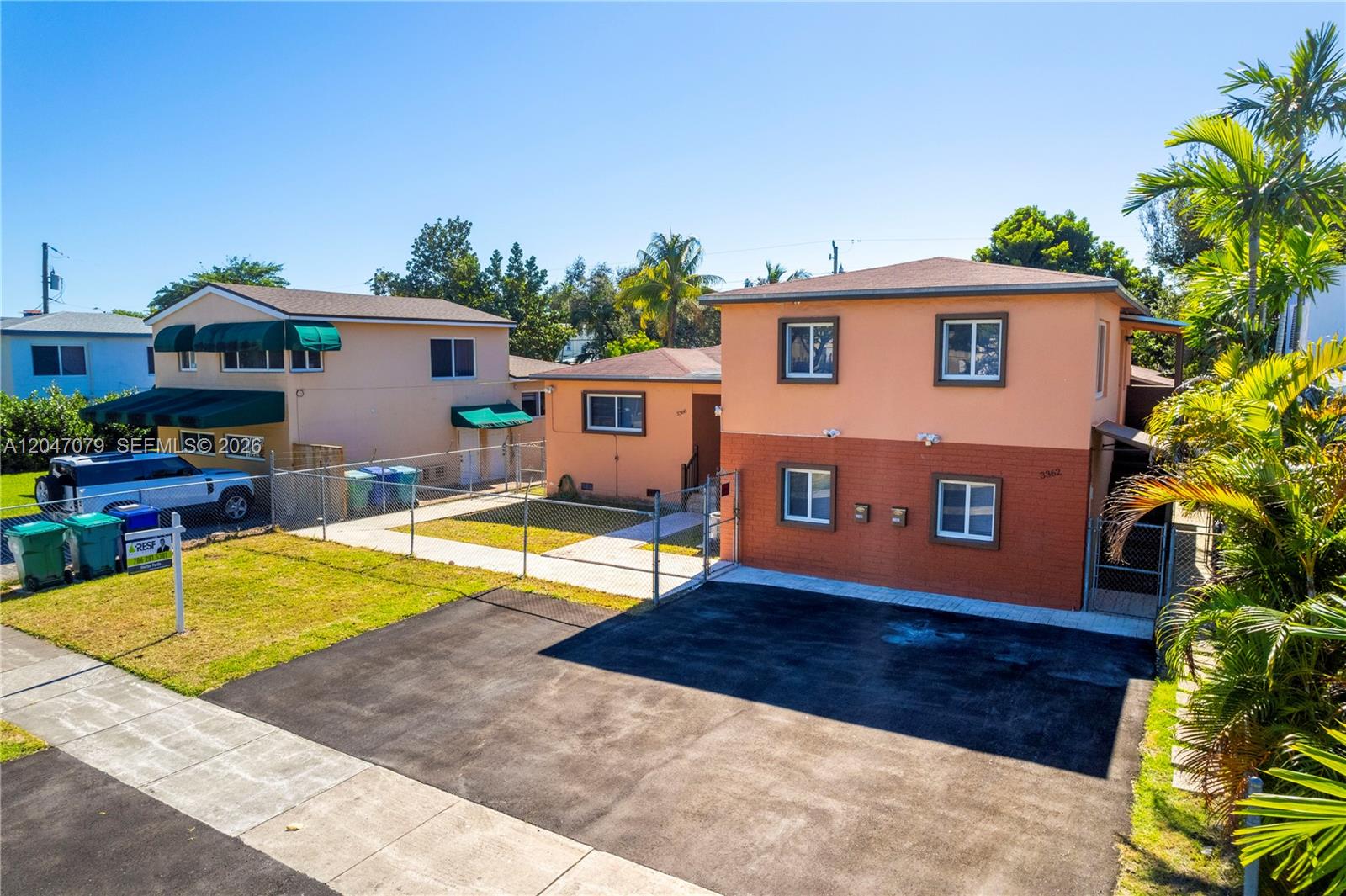 An exterior view of two adjacent two-story residential buildings with paved driveways and chain-link fencing — 3360 SW 6th St, Miami FL 33135, MIAMI, FL