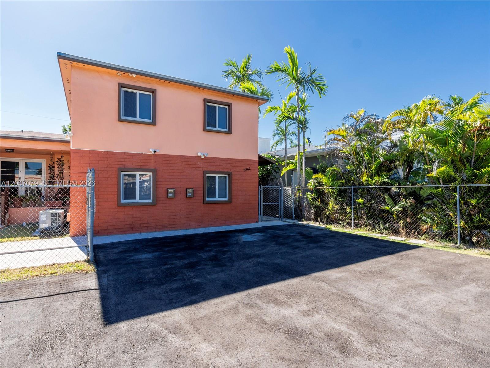 A two-story building with a peach and red brick exterior features a paved driveway — 3360 SW 6th St, Miami FL 33135, MIAMI, FL