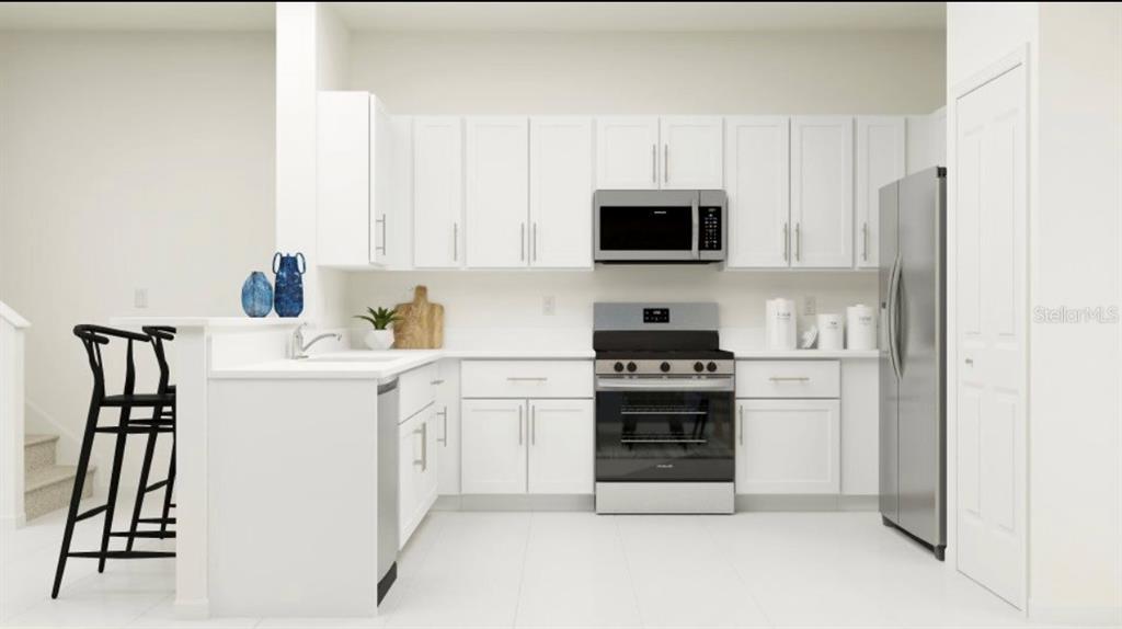 This kitchen rendering features white cabinetry, stainless steel appliances, and a breakfast bar with seating — 208 27TH STREET SE, RUSKIN, FL