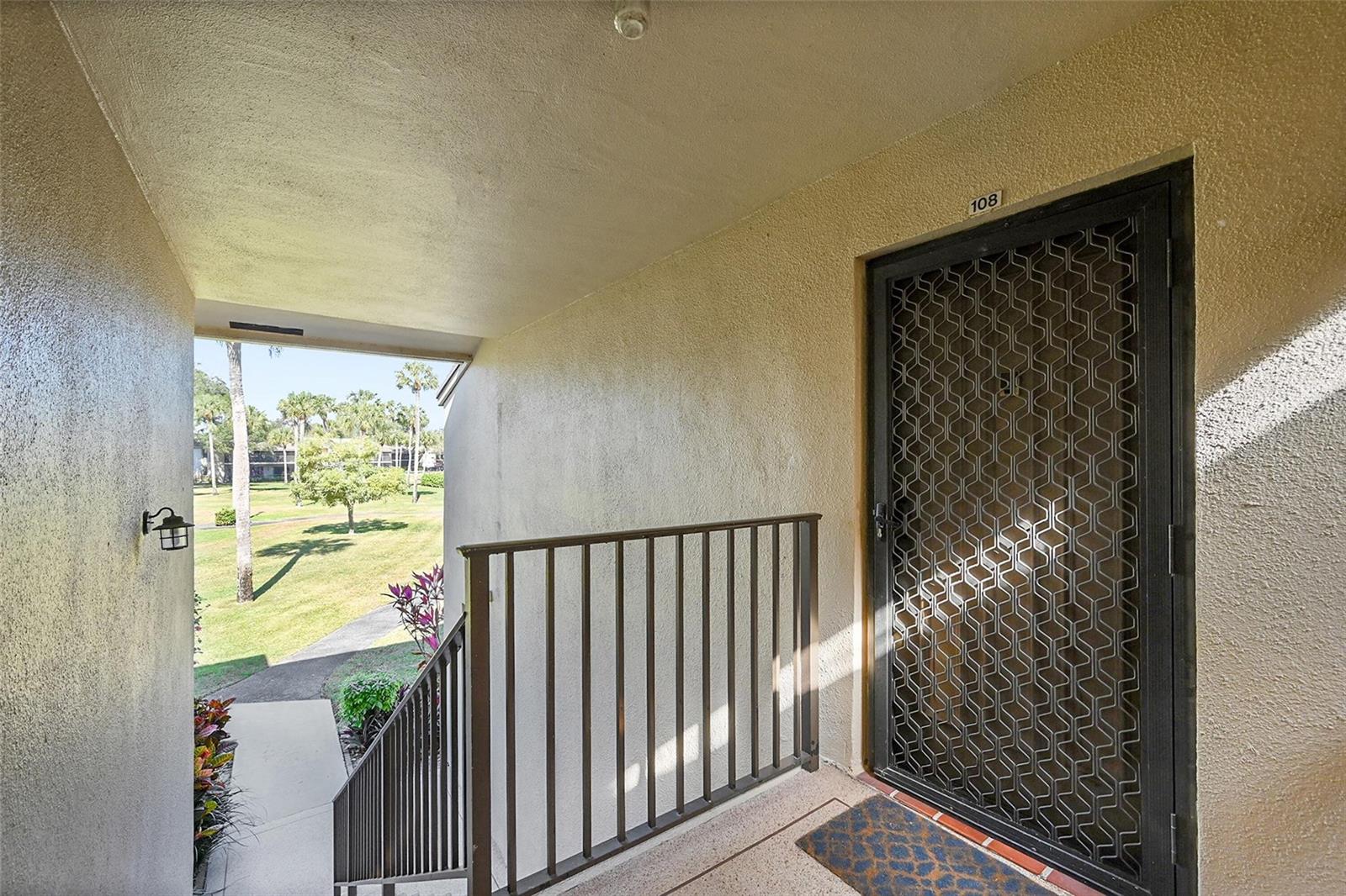 An exterior view of a building entrance with a metal security door numbered 108 — 111 Deer Creek Boulevard # 108, Deerfield Beach FL 33442, DEERFIELD BEACH, FL