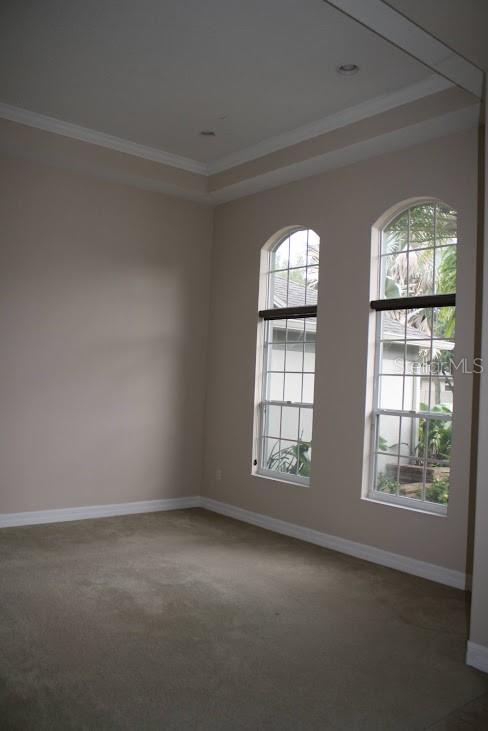 An empty room with beige carpet, light-colored walls, and two arched windows — 2461 WOODBARK STREET, APOPKA, FL