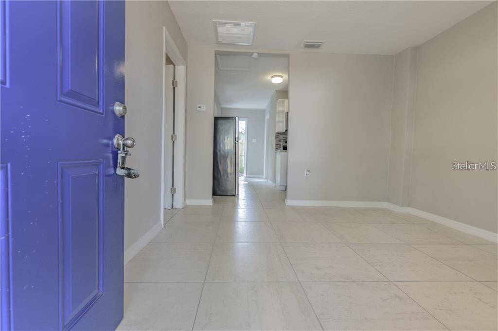 A view from a blue front door into a room with light-colored tile flooring — 5106 W RICHARDSON AVENUE UNIT B, TAMPA, FL