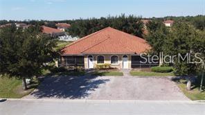 An aerial view shows a single-story house with a red tile roof and paved driveway — 1558 CUMIN DRIVE, POINCIANA, FL