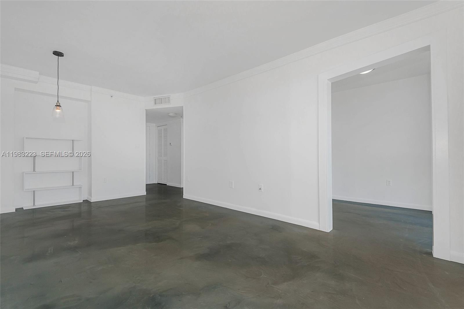 An interior view shows a room with white walls, a polished concrete floor, and shelving — 1688 West Ave # 07, Miami Beach FL 33139, MIAMI BEACH, FL