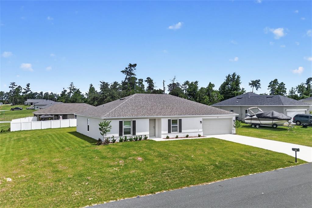 A single-story white house with a gray shingled roof and an attached two-car garage — 2686 SW 161ST LOOP, OCALA, FL