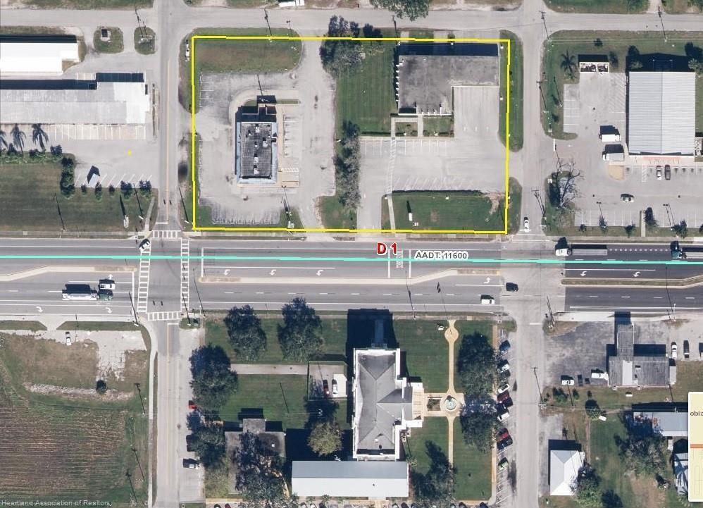 An aerial view shows a commercial property with two buildings and parking lots outlined in yellow — 599 US 27, Moore Haven FL 33471, MOORE HAVEN, FL