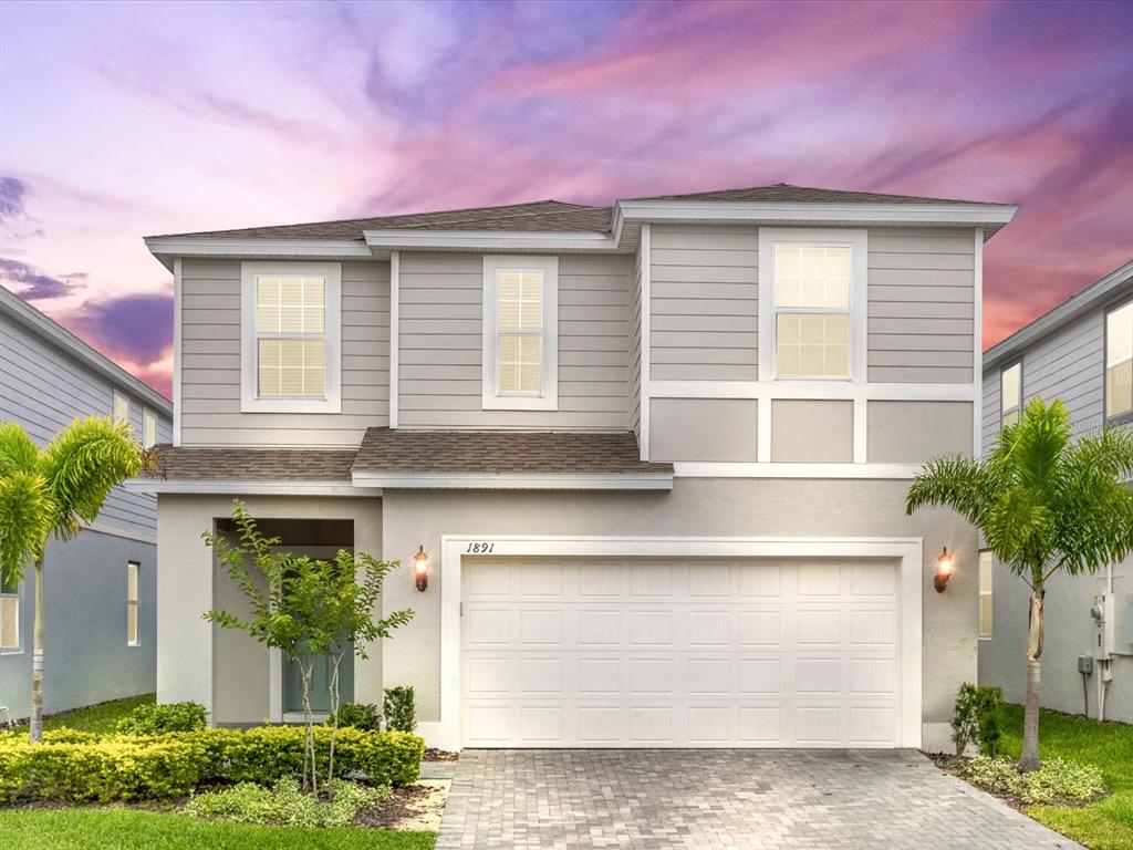 A two-story house with a gray exterior, a two-car garage, and a paved driveway — 1891 SUMMER DRIVE, DAVENPORT, FL