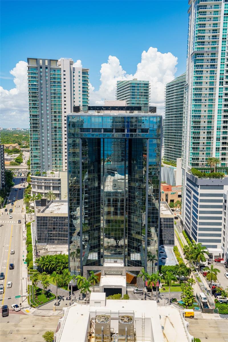An aerial view of a glass-facade office building surrounded by high-rise residential towers and streets — 1200 Brickell Ave # B, Miami FL 33131, MIAMI, FL