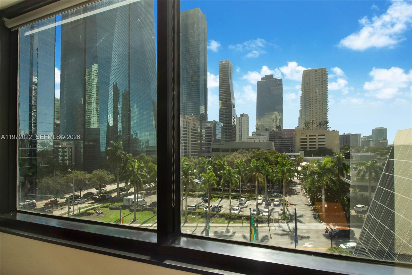 A view of a city skyline and parking lot seen through a large window — 1200 Brickell Ave # B, Miami FL 33131, MIAMI, FL