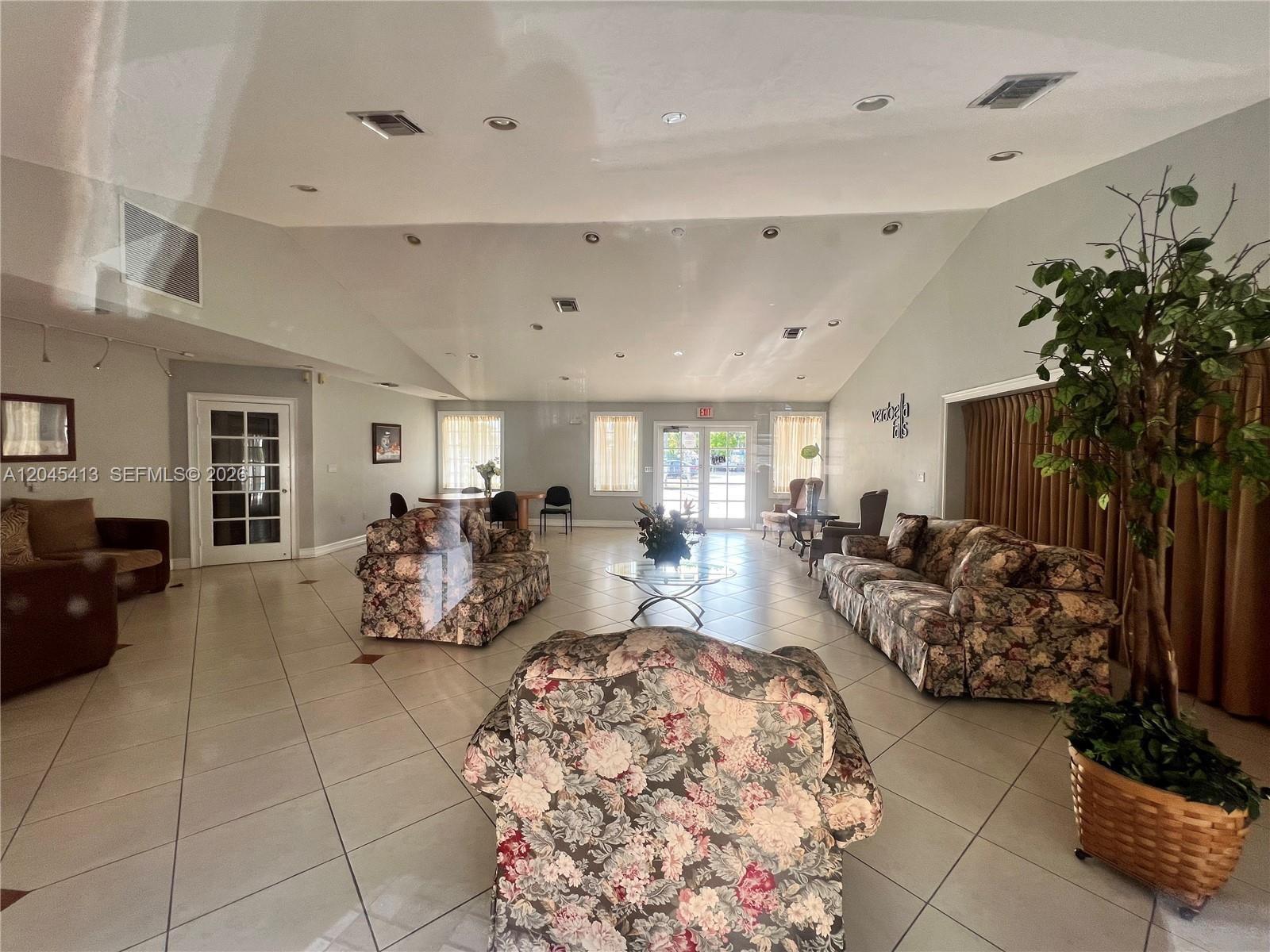 A spacious lobby features tile flooring, vaulted ceilings, and several floral-patterned sofas — 8255 SW 152nd Ave # 209, Miami FL 33193, MIAMI, FL