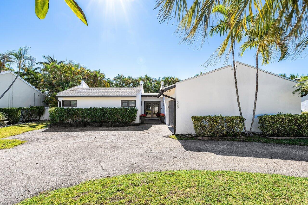 A single-story white house with a paved driveway, palm trees, and manicured hedges — 630 NE 15th Place, Boynton Beach FL 33435, BOYNTON BEACH, FL
