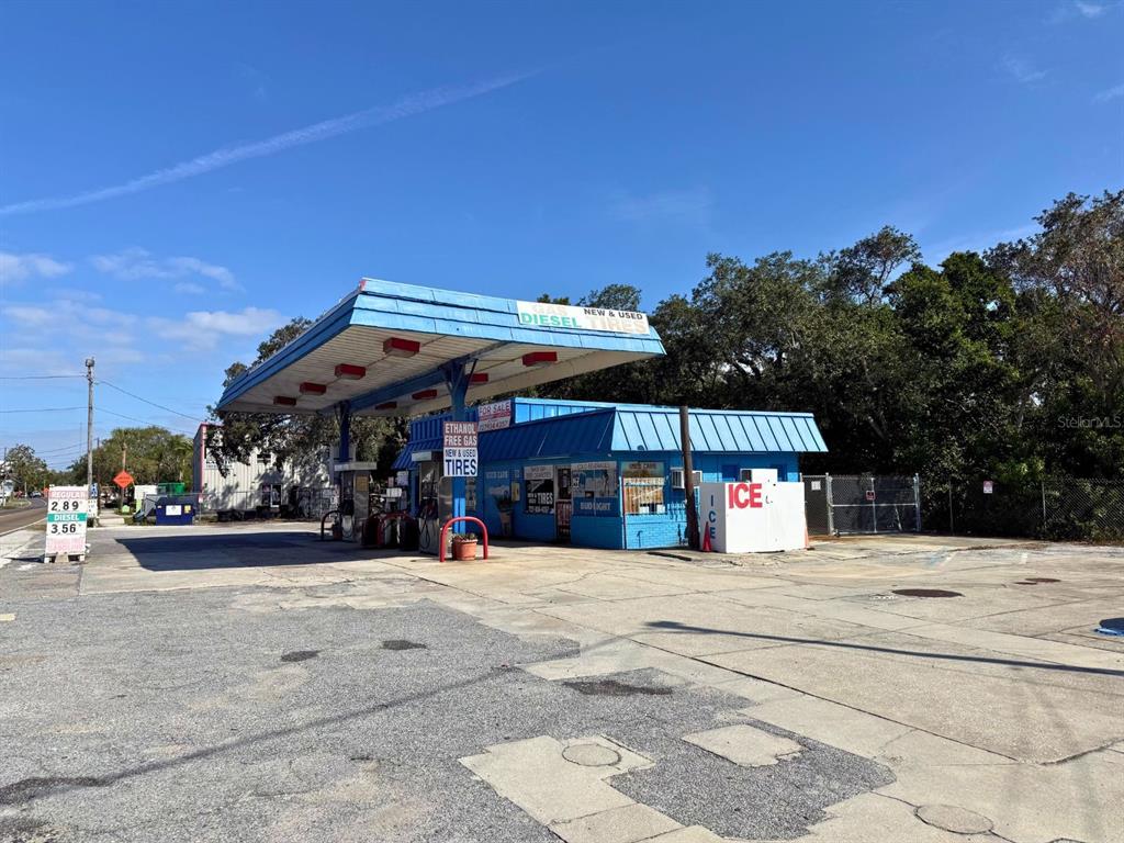 A blue gas station with a canopy, fuel pumps, and a small convenience store building — 1941 S PINELLAS AVENUE, TARPON SPRINGS, FL