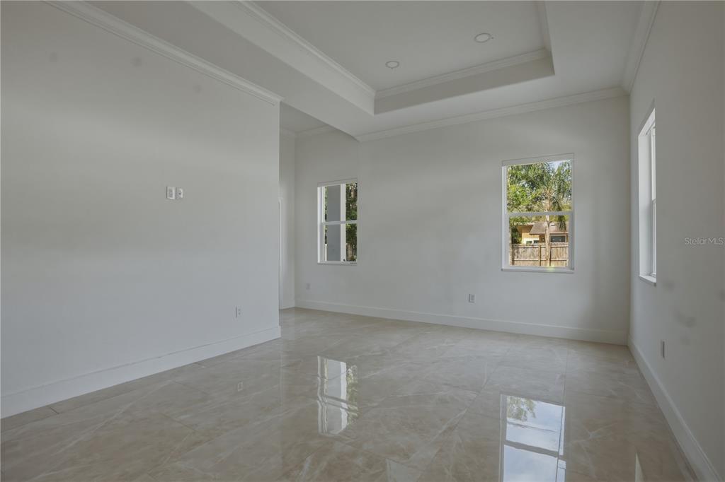 An empty room with white walls, a tray ceiling, and light-colored tile flooring — 685 1ST AVENUE N, SAFETY HARBOR, FL