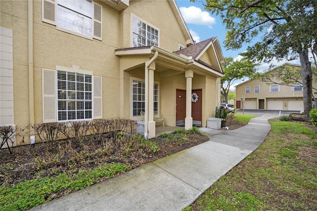 A beige two-story townhouse exterior features a covered entryway with two brown front doors — 839 GRAND REGENCY POINT UNIT 104, ALTAMONTE SPRINGS, FL