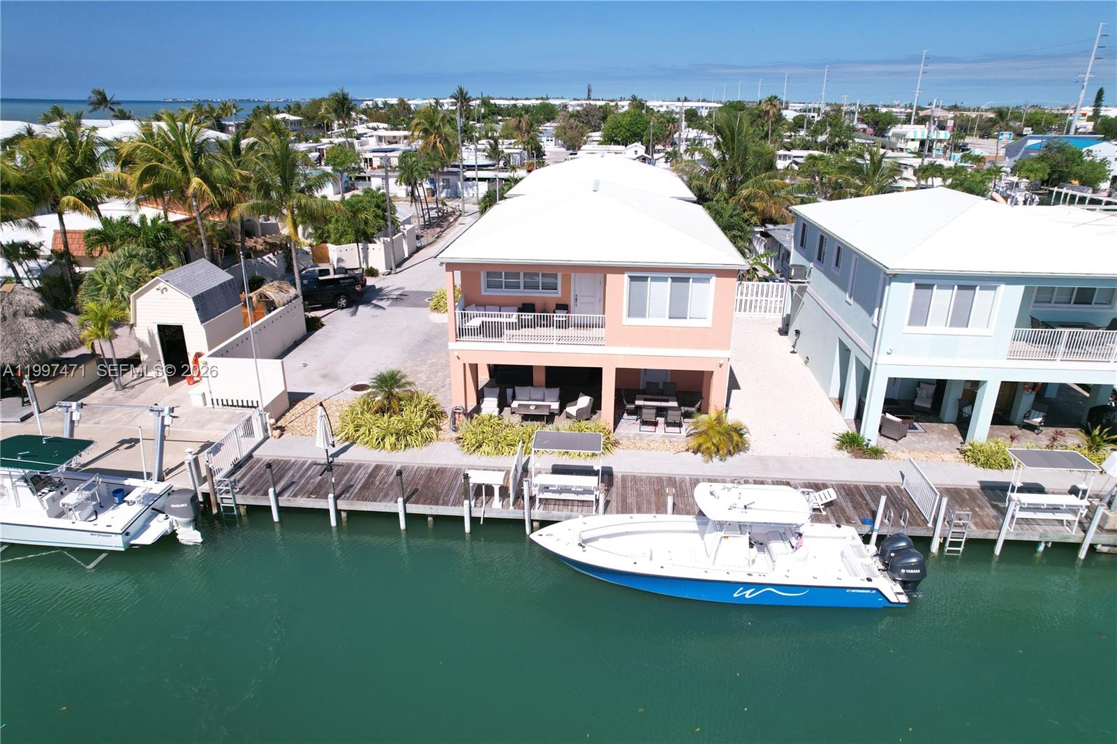 An aerial view shows two waterfront houses with boat docks and moored boats — 11284 3rd Avenue Ocean, Marathon FL 33050, MARATHON, FL