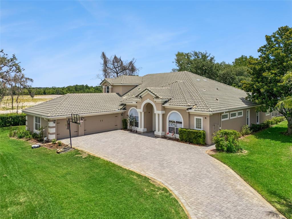 An aerial view of a single-story house with a tiled roof and a paved driveway — 1700 LAKE ROBERTS COURT, WINDERMERE, FL