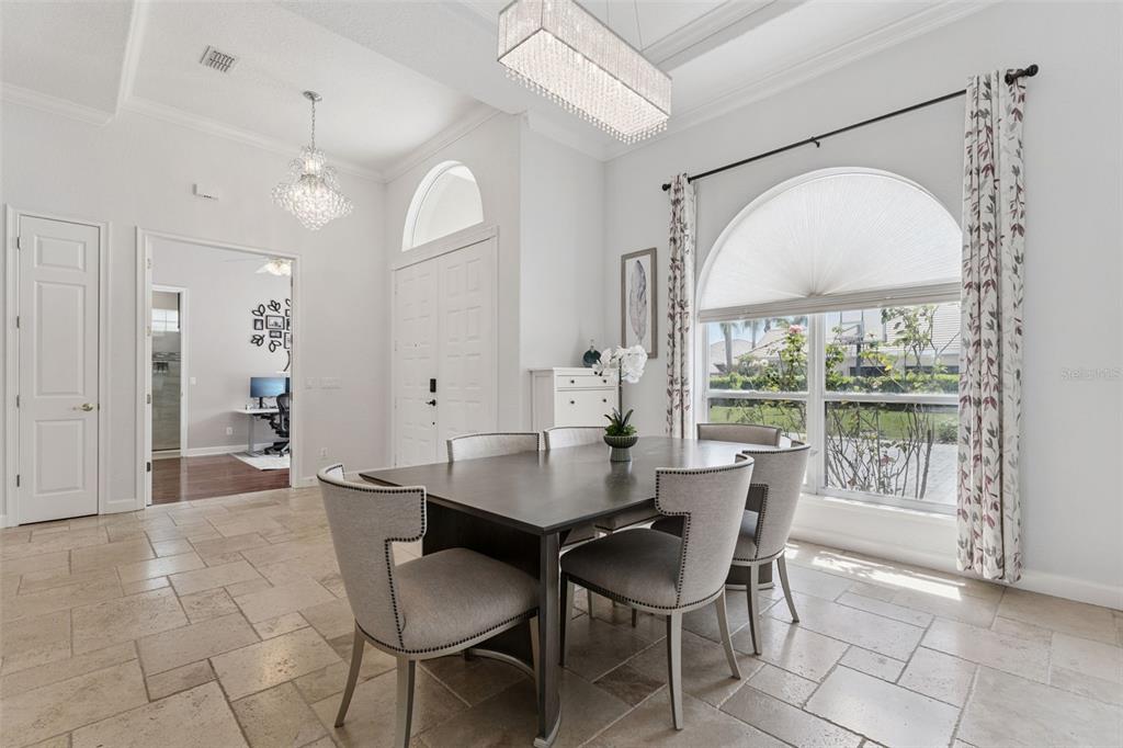 A dining room features a dark wood table, upholstered chairs, tile flooring, and a large window — 1700 LAKE ROBERTS COURT, WINDERMERE, FL