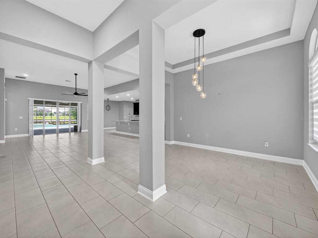 An open-concept living area features light gray walls, tile flooring, and a modern pendant light — 17614 SAILFIN DRIVE, ORLANDO, FL