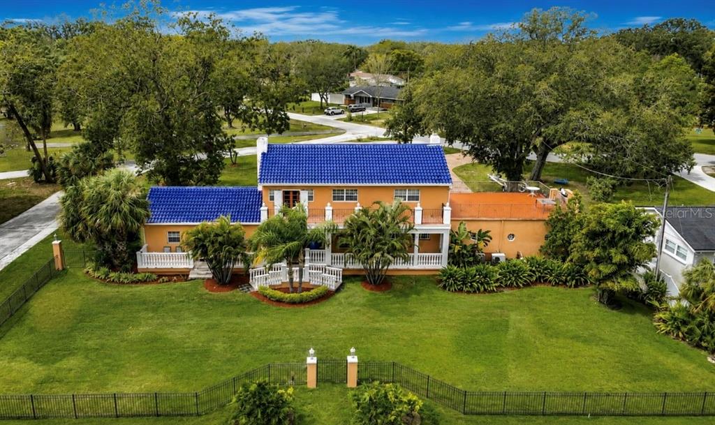 An aerial view of a two-story house with a blue tile roof and orange stucco exterior — 4929 N RIVER SHORE DRIVE UNIT A, TAMPA, FL