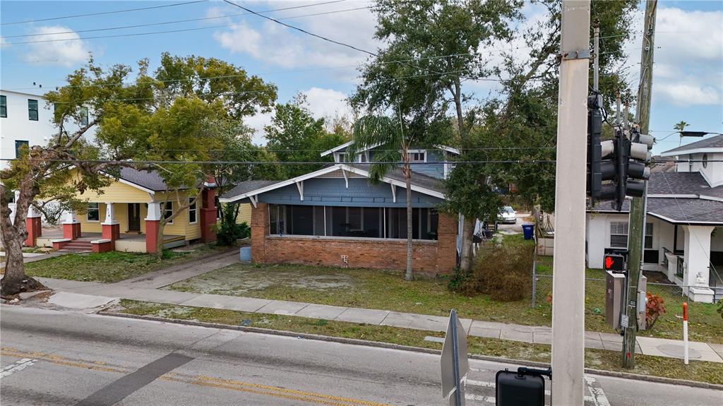 An exterior view of a blue house with a brick base and a screened-in porch — 316 W COLUMBUS DRIVE, TAMPA, FL