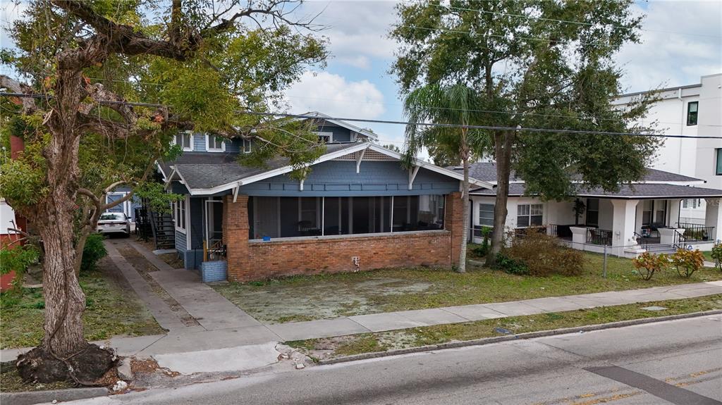 A blue house with a brick-based screened porch sits next to a white house — 316 W COLUMBUS DRIVE, TAMPA, FL