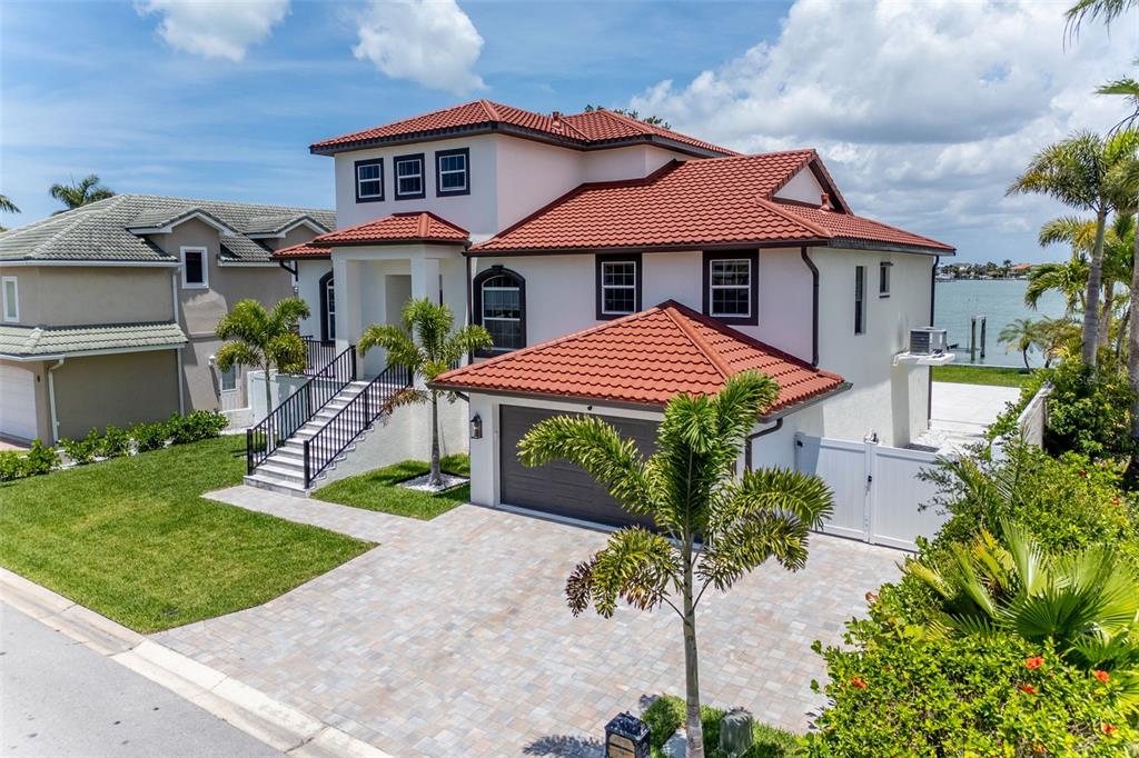 An exterior view of a two-story house with a red tile roof and garage — 4 PARADISE LANE, TREASURE ISLAND, FL