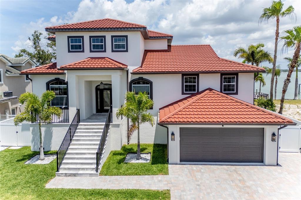 A two-story house with a red tile roof, white stucco walls, and a front staircase — 4 PARADISE LANE, TREASURE ISLAND, FL