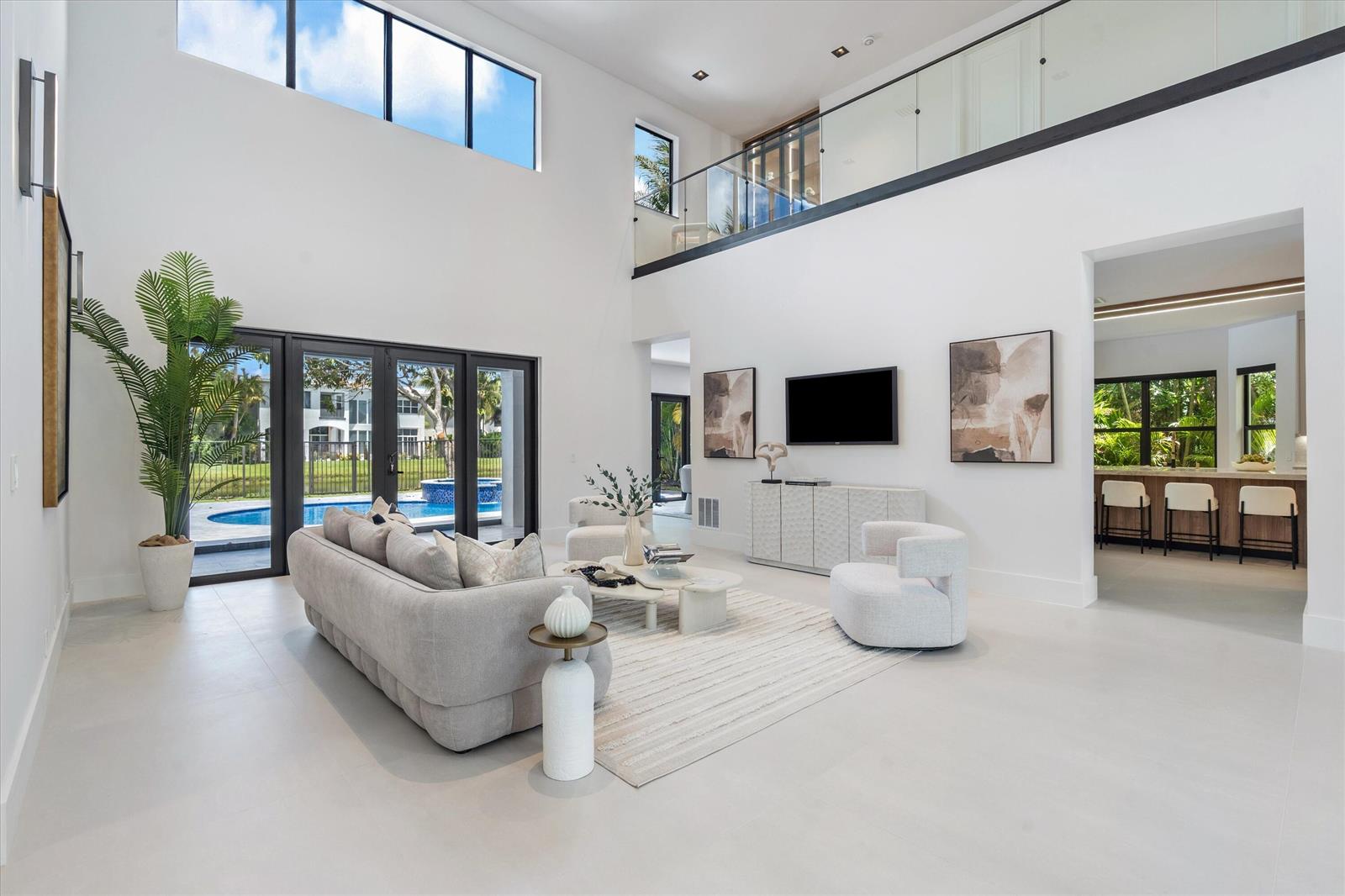 A modern living room with a glass-topped table, floating staircase, and double-height ceilings — 17585 Middlebrook Way, Boca Raton FL 33496, BOCA RATON, FL