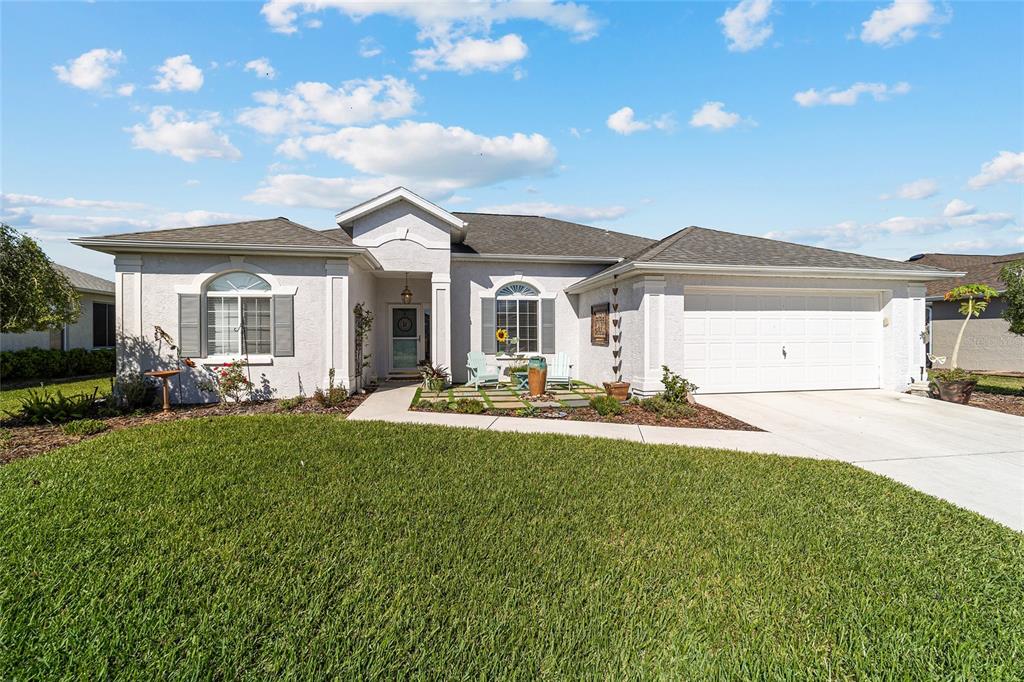 A single-story house with a white stucco exterior, a two-car garage, and a front lawn — 2380 NW 55TH AVENUE ROAD, OCALA, FL